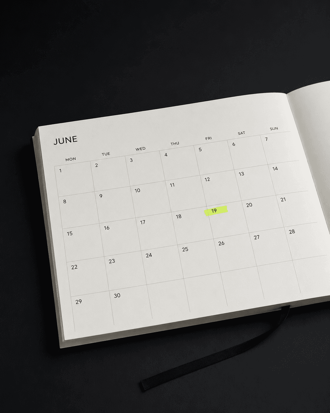 Open minimal desk calendar with one date marked by a lime highlighter swipe