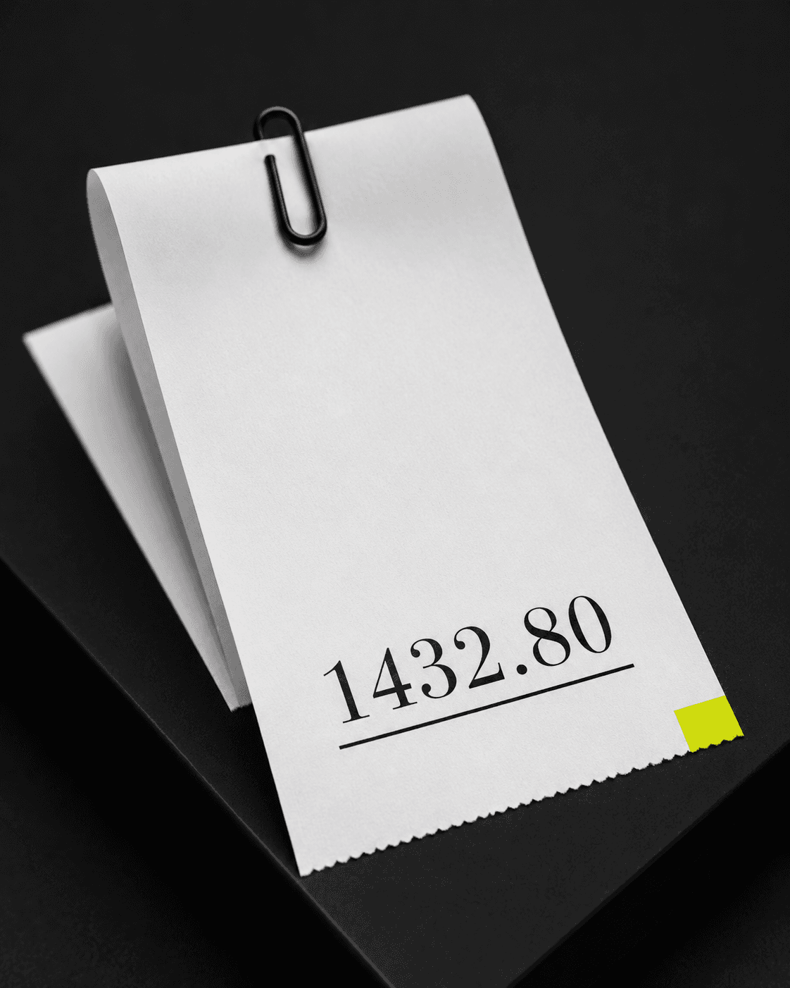 Printed receipt strip showing a final monetary total on a matte black surface